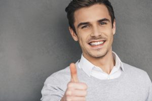Man giving thumbs up for dental implants success