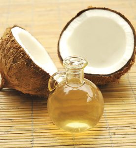 Coconut Oil in a bottle and coconut split in half.