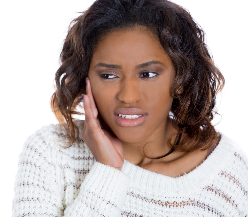 Woman with TMJ pain holding her jaw