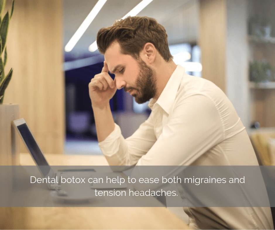 Man sitting at a desk with a headache.