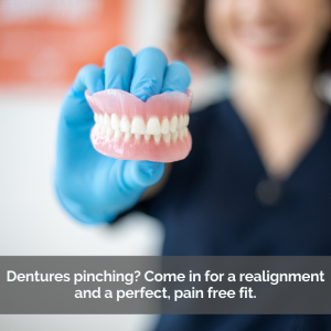 Dentist showing a pair of dentures in her hand.