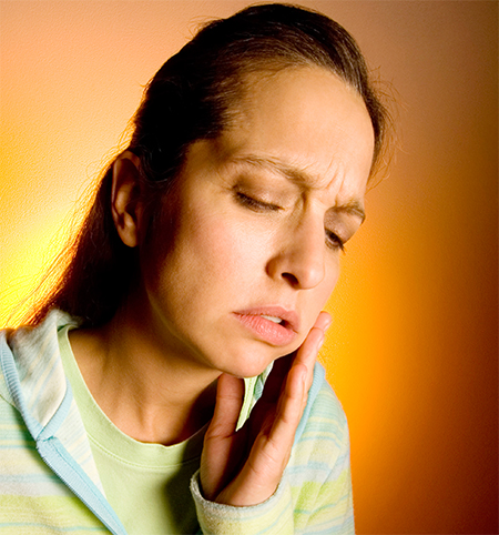 Woman holding her cheek in pain