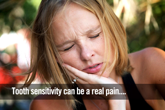 Woman holding her cheek in pain from tooth ache