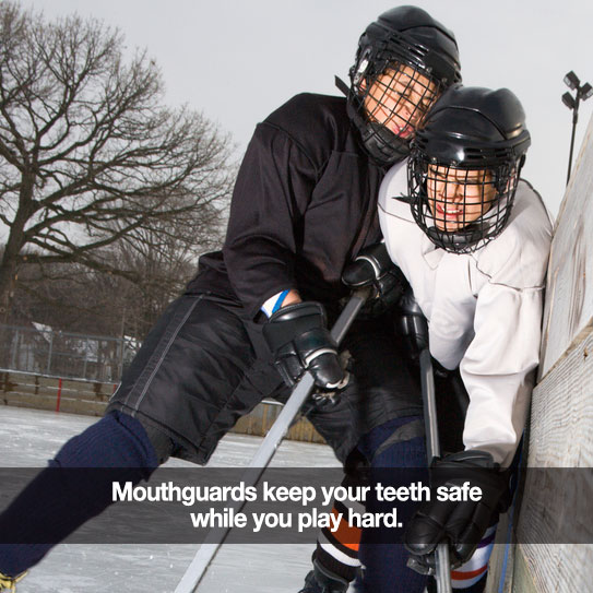 Two boys playing hocky. Caption: Mouthguards keep your teeth safe.