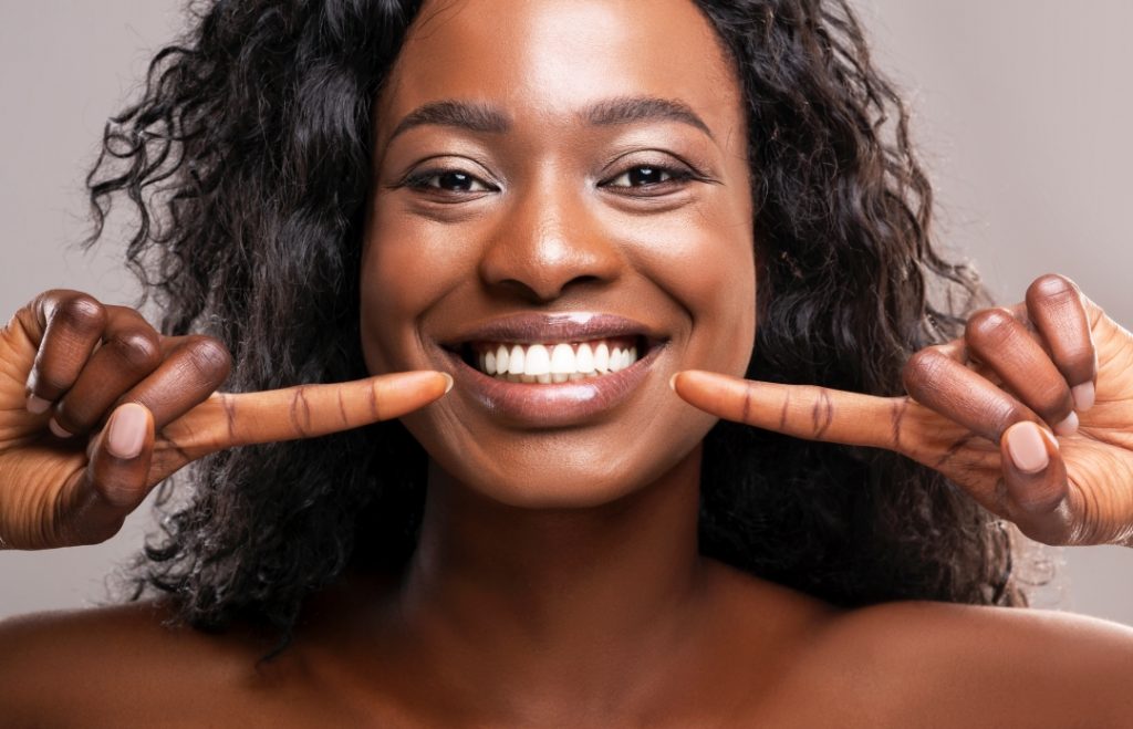 Woman pointing at her dental veneers