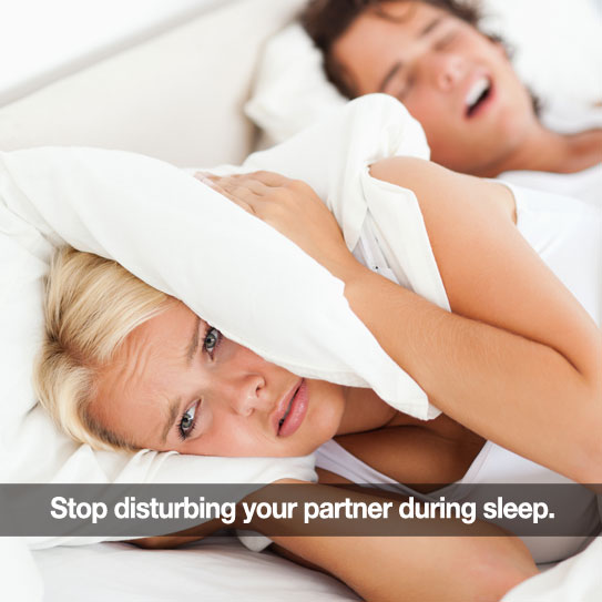 Woman can't sleep because partner is snoring. Holding pillow over her ears.