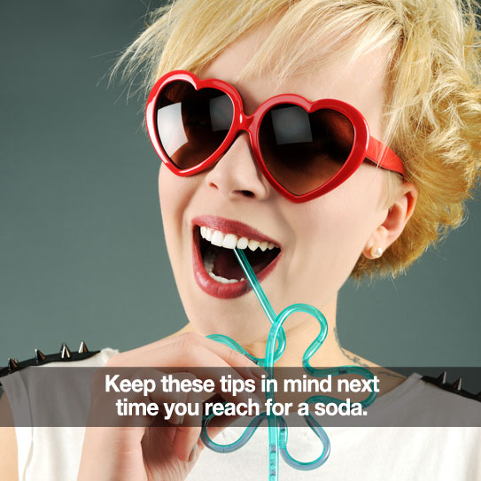 Woman in heart glasses drinking from a winding straw.