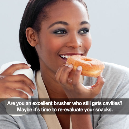 beautiful woman eating a donut and holding a cup of coffee.