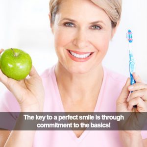 Woman holding a green apple in one hand and a tooth brush in the other