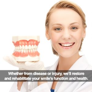 Female dentist holding teeth model. Caption: ...We'll restore and rehabilitate your smile