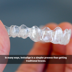 A hand holding an Invisalign aligner.