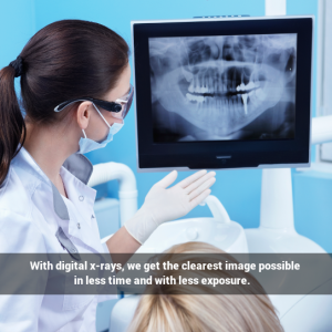 Female dentist with female patient looking at X-rays.