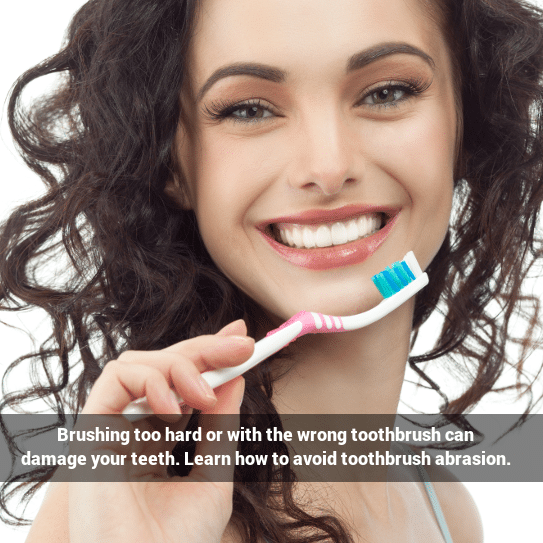 Preventing toothbrush abrasion: A woman with a smile holding up a toothbrush 