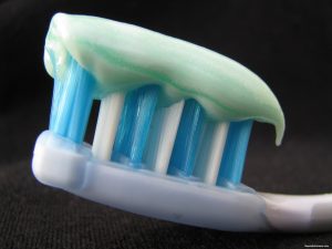 Toothbrush with toothpaste on black background.