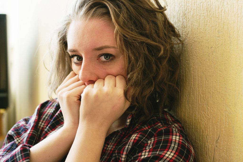 Young women coving her mouth with her hands looking fearful