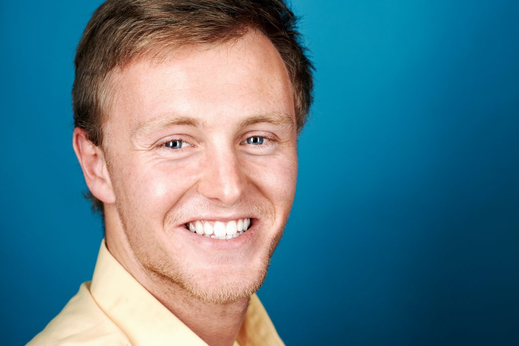 Middle aged man smiling over blue background