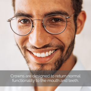 Dental crowns: A man with glasses smiles with healthy looking teeth.