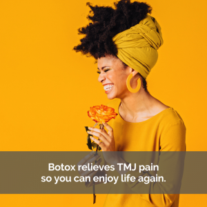 Black woman with a big smile dressed in yellow over a yellow background holding a yellow flower