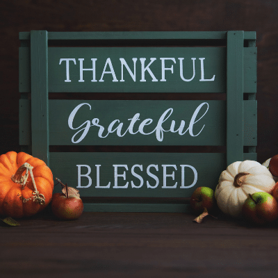 Thanksgiving scene with "Thankful," "Grateful," "Blessed" written on a wood crate