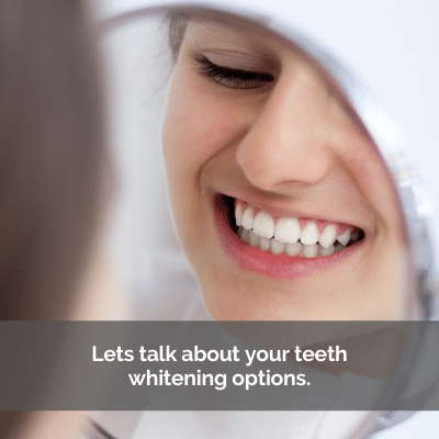 Woman with white teeth looking at her smile in the mirror.