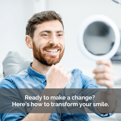 Man looking at his smile makeover in a mirror