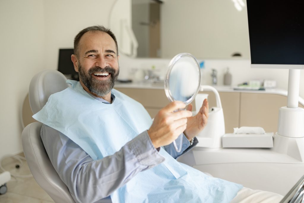 Happy male patient enjoying dental treatment to save teeth.