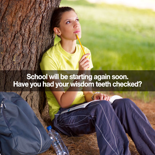 Student sitting next to a tree studying