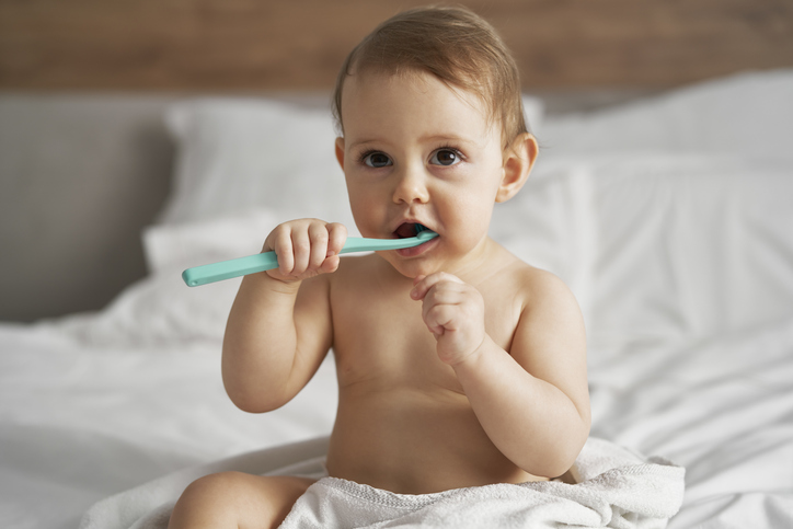 baby chewing on a toothbrush