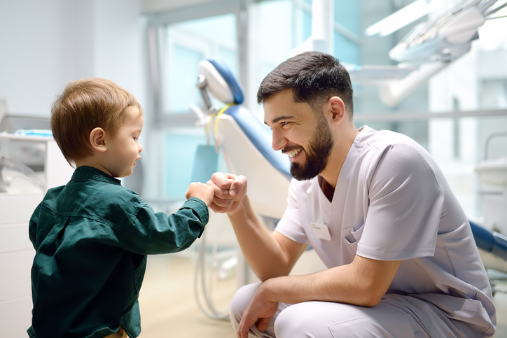 dentist giving a toddler patient a fist bump