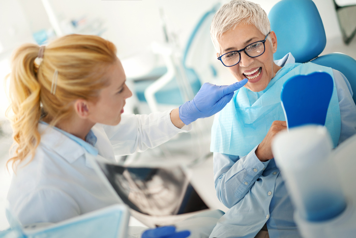 senior dental implant patient happy with her new natural-looking teeth.