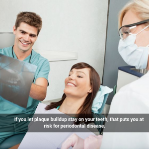 Dentist and assistant showing X-ray to female patient