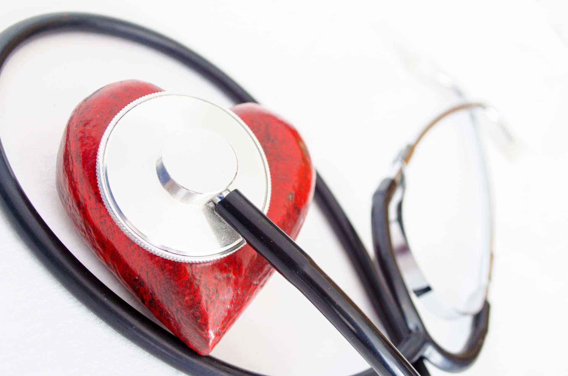 stethoscope over heart on white background