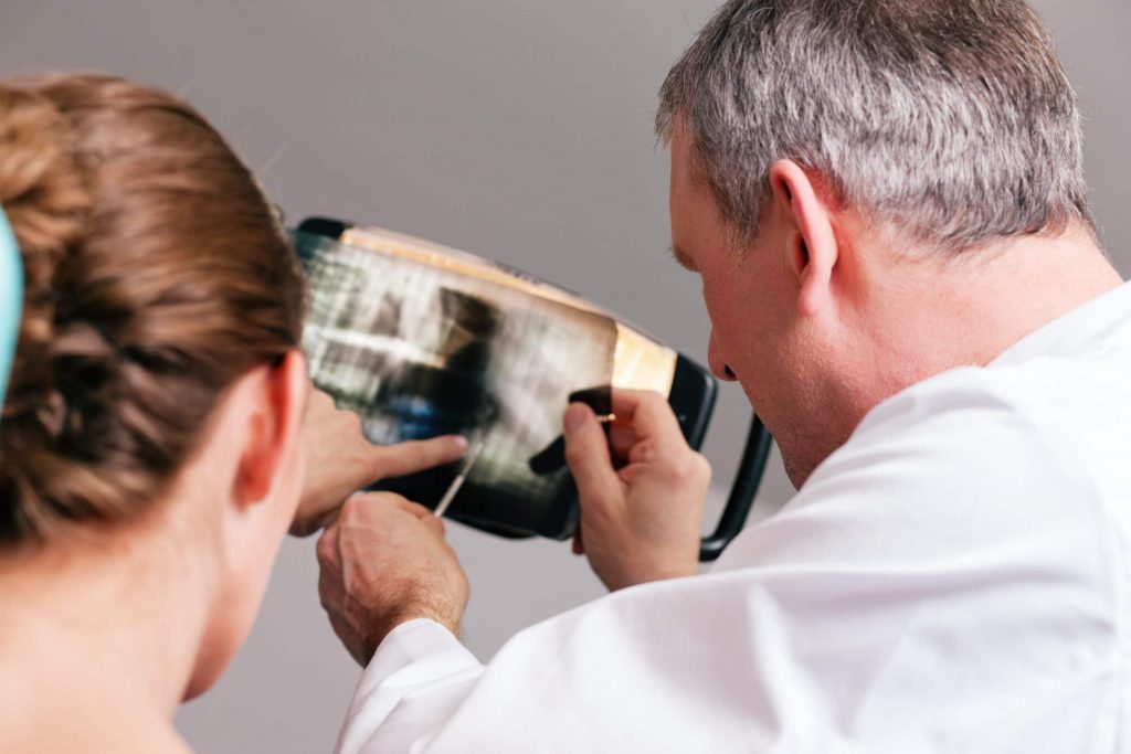 A periodontist in Boston reviewing an x-ray with a patient.
