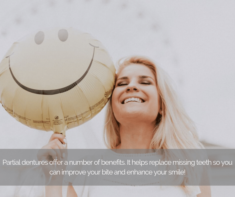 Woman smiling holding a balloon with a smiling face.