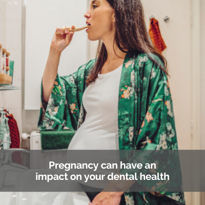 Pregnant woman brushing her teeth in her bathroom.