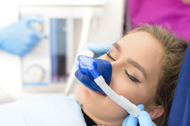 Beautiful getting woman inhalation sedation dentistry at dental clinic