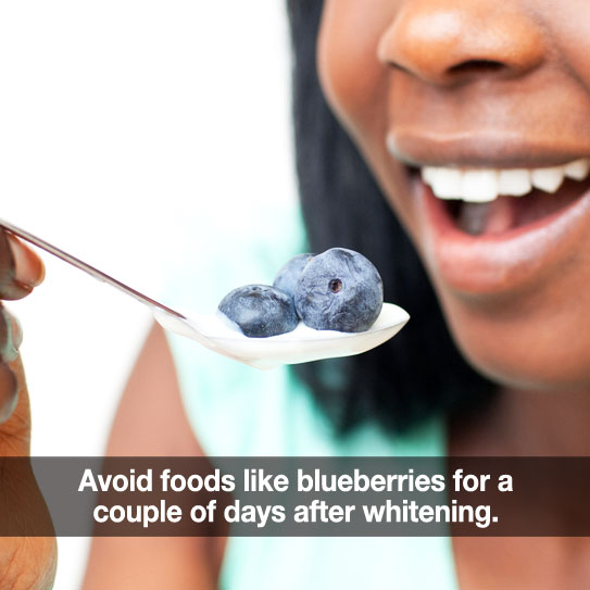 Woman eating blueberries after teeth whitening