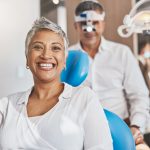 A senior female dental patient in a dental office for implant-supported dentures