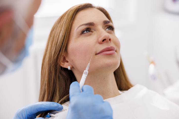woman is getting a cosmetic injection treatment