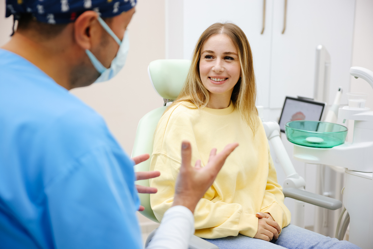 Dentist explains a dental crown procedure to a female patient - Dental Partners of Boston