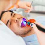 man getting cosmetic dental bonding procedure