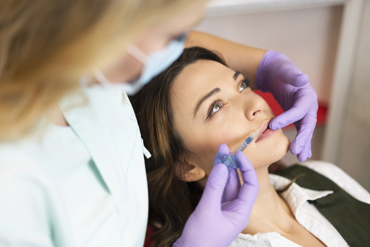 Attractive woman getting a lip filler treatment at the dental office.