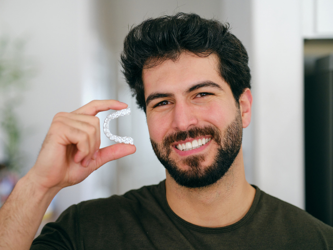 a man holding up his clear retainers